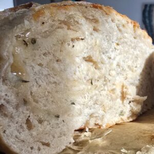 Freshly baked rosemary, parmesan cheese, and garlic sourdough bread with a golden crust, made using natural fermentation